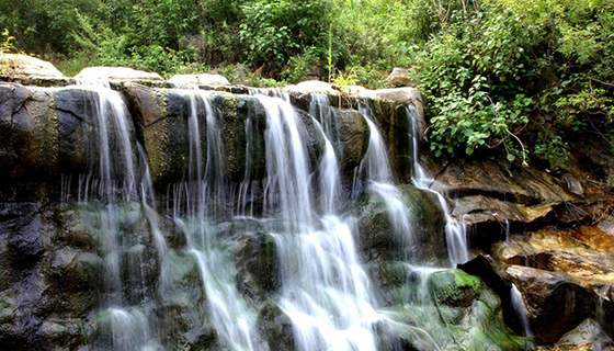 两岸高峰耸立,气势恢宏,沟里高处群山如画屏,山中花木如锦绣,多孔泉