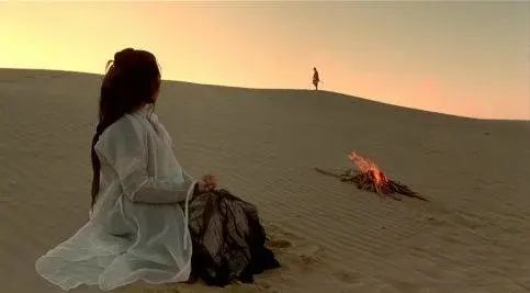 那副画面:荒凉的大漠上,至尊宝渐行渐远的背影模糊不见,紫霞只是远望